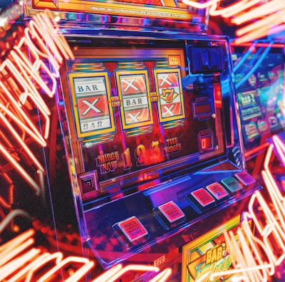 A vibrant scene featuring a classic slot machine with bright neon lights surrounding it. The slot machine displays symbols like 'Bar' and '7' and is set in a lively arcade environment. Reflections and colorful lighting add a sense of excitement and motion.